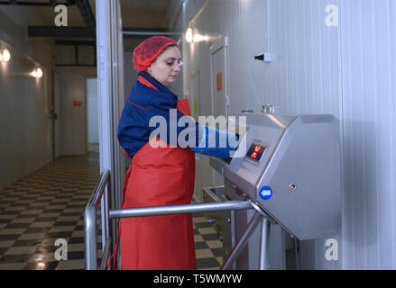 Presso la sala di ispezione sanitaria. Lavoratore disinfettante le mani prima di entrare nell'officina di macellazione. Aprile 22, 2019. Kiev, Ucraina Foto Stock