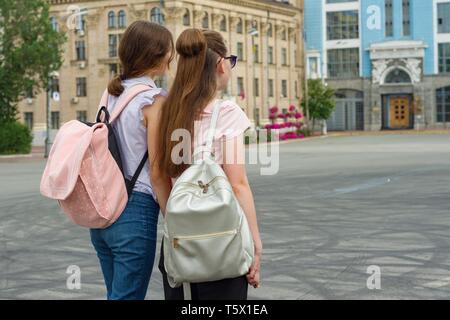 Ragazze studente con zaini, vista posteriore, città di sfondo, spazio di copia Foto Stock