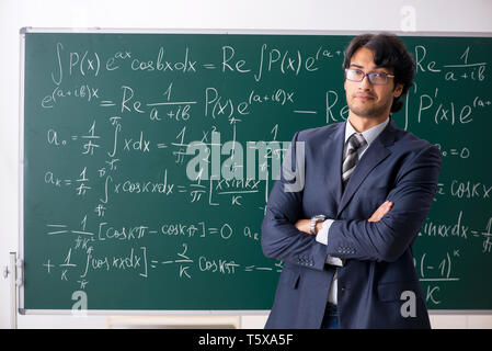 Giovane maschio insegnante di matematica in aula Foto Stock