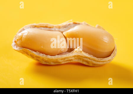Aperto peanut su sfondo giallo close up Foto Stock