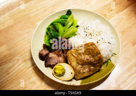 Topping di riso anatra arrosto e croccante maiale e tofu e uova sode o stile cinese per la vendita in un ristorante locale in Shantou città o città Swatow nel Guangdong Foto Stock