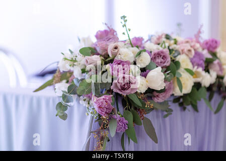 Lunga e bella composizione da fiori freschi sul tavolo. Fiori delicati decorano una tabella di nozze Foto Stock