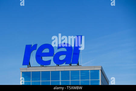 TOENISVORST, Germania - marzo 22. 2019: chiusura del logo del reale (catena di supermercati tedesca) contro il cielo blu chiaro Foto Stock