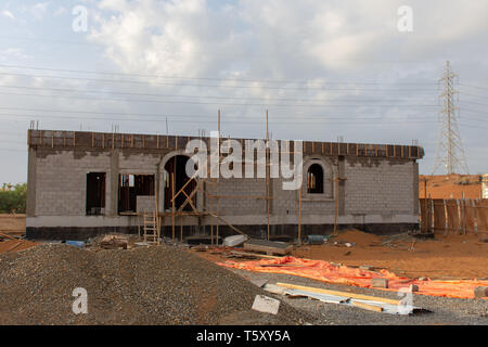 Sito in costruzione negli Emirati Arabi Uniti al tramonto mostra nuovo edificio nel pomeriggio nuvoloso. Foto Stock