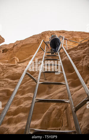 La donna sale una scala a gli archi di roccia in timna parco nazionale nel sud di Israele vicino Eilta Foto Stock