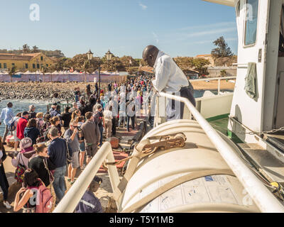 Ile de Goree, Senegal, febbraio 02, 2018: un gruppo di turisti e di gente del posto in attesa nella coda per un trasferimento in barca a Dakar in una famosa isola di slave di Gor Foto Stock