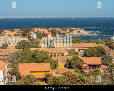 Gorea, Senegal - Febbraio 2, 2019: Vista di case con il tetto rosso sull'isola di Goree con Dakar in background. Gorée. Dakar, Senegal. L'Africa. Foto Stock