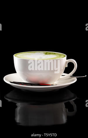 Tazza di tè verde latte isolate su sfondo nero Foto Stock