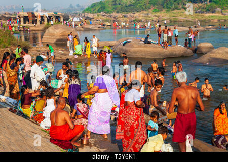 HAMPI, India - 20 febbraio 2012: popolo indiano la balneazione e lavare i loro panni nel fiume in India Foto Stock