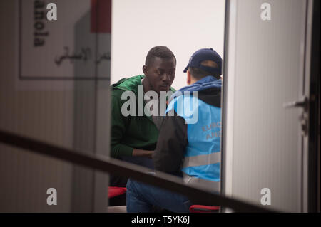 Malaga, Spagna. 28 apr, 2019. Un migrante è visto parlare con un membro di frontiera europea e Guardia costiera (Agenzia Frontex) all'interno di una situazione di emergenza umanitaria in stallo dopo il suo arrivo al porto di Malaga. Spagna's Maritime Rescue service salvato 56 migranti a bordo di un battello che attraversa il Alboran Mare e li ha portati al porto di Malaga, dove sono stati assistiti dalla Croce Rossa spagnola. Credito: Gesù Merida/SOPA Immagini/ZUMA filo/Alamy Live News Foto Stock