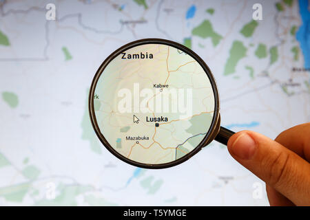 Lusaka nello Zambia. Mappa politico. Visualizzazione della città concetto illustrativa sullo schermo attraverso la lente di ingrandimento in mano. Foto Stock