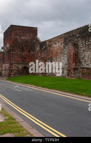 Grigio di un cielo nuvoloso di telai oltre la medievale a due piani piastrella quadrata torre costruita a filo contro il rosso dei blocchi di pietra arenaria della città di Carlisle arginato pareti Foto Stock