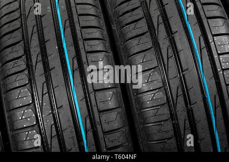 Studio shot di un set di estate pneumatici per auto su sfondo nero. Stack di pneumatico dello sfondo. Messa a fuoco selettiva. Pneumatico auto vicino. Pneumatico in gomma nero. Nuovo di zecca Foto Stock
