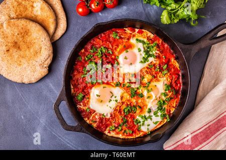 Shakshuka in una padella. Le uova in camicia in pomodoro piccante salsa di pepe. Foto Stock