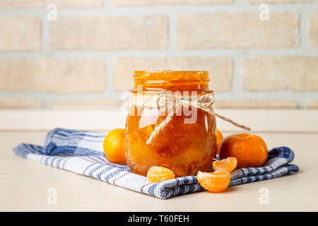 Tangerine inceppamento nel vasetto di vetro sull'asciugamano blu con frutta Foto Stock