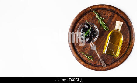 Olio di oliva e le olive in un recipiente a bordo. Foto Stock