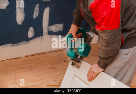 Il taglio di legno porta utensile di costruzione uomo utilizzando una sega circolare per la casa il rinnovamento, la riparazione Foto Stock