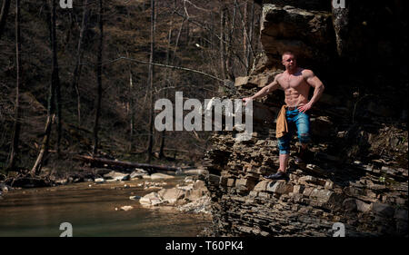 Uomo forte si arrampica su per la montagna Foto Stock