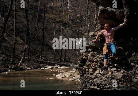 Uomo forte si arrampica su per la montagna Foto Stock