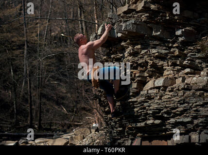 Uomo forte si arrampica su per la montagna Foto Stock