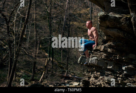 Uomo forte si arrampica su per la montagna Foto Stock