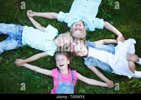 Piccoli Amici posa su erba in estate park Foto Stock