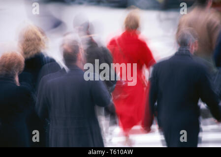 Una donna in rosso cappotto spicca nelle ore di punta della folla, NYC, STATI UNITI D'AMERICA Foto Stock