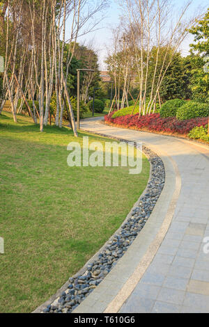 Bellissimo giardino estivo con un avvolgimento di passerella il suo modo attraverso, Silver birch e arbusto e aiuola intorno a. Fuzhou,Cina Foto Stock