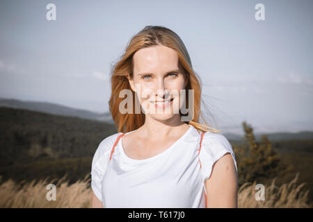 Giovane donna incinta in posa nella natura Foto Stock