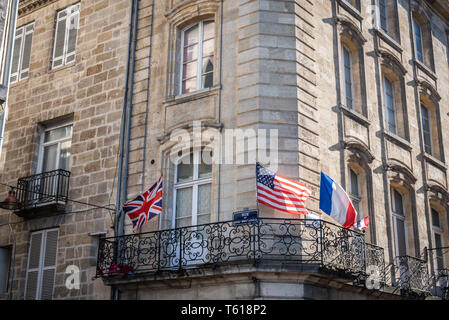 Francese, Inglese e Americana bandiere sul balcone di un edificio bordolese a Bordeaux Foto Stock