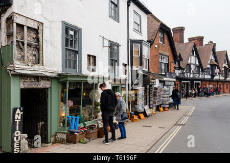 Shopers guardando antichi oggetti di posta indesiderata per la vendita al di fuori di un vecchio negozio di antiquariato in High Street, Arundel, West Sussex, in Inghilterra, Regno Unito, Gran Bretagna Foto Stock