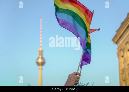 Basso angolo vista di mano azienda bandiera arcobaleno durante il CSD-Parade di Berlino Foto Stock
