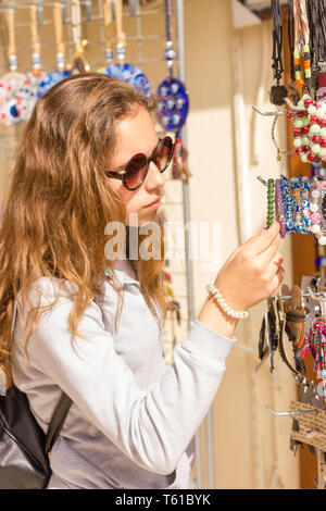 Giovane bella ragazza sceglie jewelery tradizionale presso il bazar turco nella città vecchia di Antalya Foto Stock