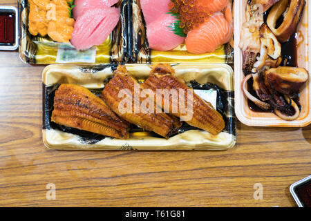 Anguilla sushi, e altri sushi; salmone, otoro, trasandato, Grigliata di gamberi, granchi sono disposti sul tavolo pronti a mangiare. Foto Stock