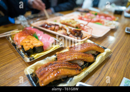 Anguilla sushi, e altri sushi; salmone, otoro, trasandato, Grigliata di gamberi, granchi sono disposti sul tavolo pronti a mangiare. Foto Stock