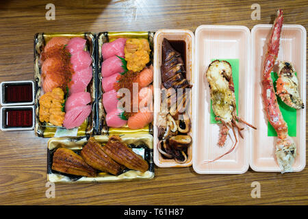Il Sushi e sefood pranzo; salmone, otoro, trasandato, anguilla sushi, e Grigliata di gamberi, granchi di grandi dimensioni, sono disposti sul tavolo pronti a mangiare. Foto Stock