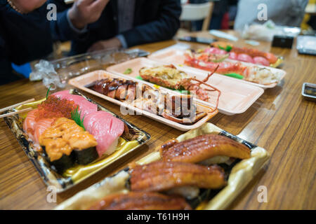 Calamari alla griglia e altri sushi; salmone, otoro, anguilla, Grigliata di gamberi, granchi sono disposti sul tavolo pronti a mangiare. Foto Stock