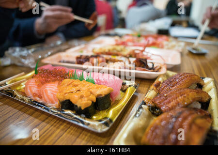 Shaddy sushi, e altri sushi; salmone, otoro, anguilla, Grigliata di gamberi, granchi sono disposti sul tavolo pronti a mangiare. Foto Stock