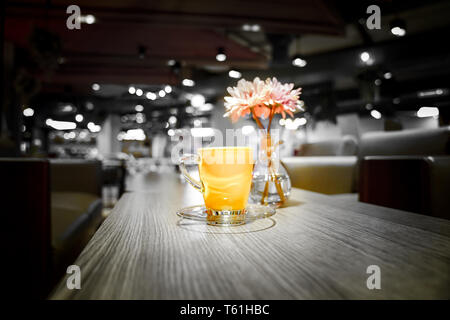 Caffè caldo color evidenziare con luce fiore rosa accanto a. Foto Stock