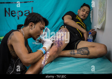 Un uomo come ottenere un tatuaggio al tatuaggio annuale convention di Kathmandu, Nepal Foto Stock