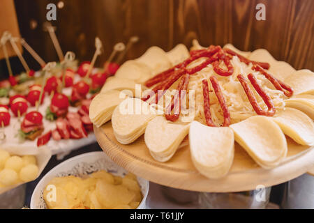 Festosa buffet salato, carne, pesce e patatine, palline di formaggio e altre specialità per la celebrazione di matrimoni e altri eventi ben decorate Foto Stock