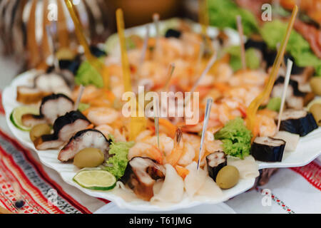 Festosa buffet salato, carne, pesce e patatine, palline di formaggio e altre specialità per la celebrazione di matrimoni e altri eventi ben decorate Foto Stock