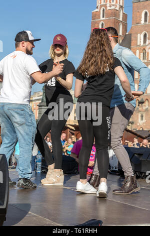 Cracow Polonia - Marzo 30, 2019: International Flashmob Giorno della rueda de casino. Diverse centinaia di persone di danza ritmi ispanica nella piazza principale di Foto Stock