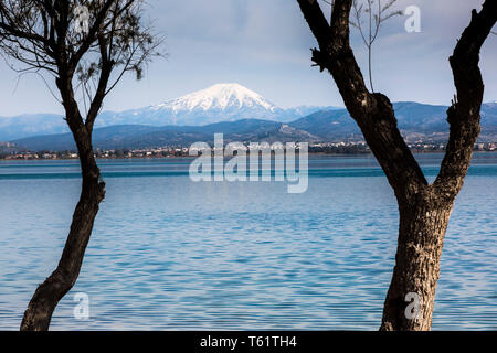 Visto da Avlida la strada sul mare,il Monte Olimpo, tradizionalmente conosciuta come la casa delle antiche divinità greche, spinge il suo picco innevato all'orizzonte. Foto Stock