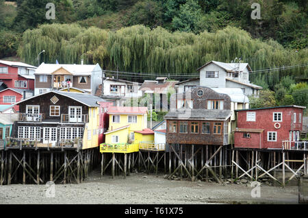 Case su palafitte, palafitos, con la bassa marea, in corrispondenza del bordo di Chiloé isola della capitale, Castro, in Cile Foto Stock