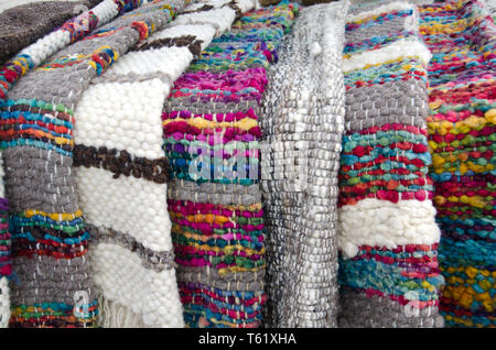 Tappeti colorati sono tra la vasta gamma di maglia spessa vestiti e merci in vendita nella Delcahue artigianale sul mercato del Cile isola di Chiloé Foto Stock