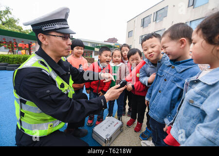 Changxing cinese della provincia dello Zhejiang. 28 apr, 2019. Un poliziotto dimostra l'uso di alcometer in un asilo nido nel Lijiaxiang township di Changxing County, est della Cina di Provincia dello Zhejiang, 28 aprile 2019. Changxing polizia stradale terrà un vasto programma sulla sicurezza stradale in un asilo nido così i bambini possono imparare circa le norme sul traffico. Credito: Xu Yu/Xinhua/Alamy Live News Foto Stock