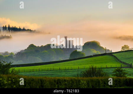 Hornby, Lancaster, Regno Unito Meteo. Misty, umido e frizzante aprile mattina sopra il Castello di Hornby e i campi calcinati del Lancashire rurale. Castello di Hornby una casa di campagna, sviluppata da un castello medievale, che si erge ad est del villaggio di Hornby nella Valle di Lune, Lancashire. Occupa una posizione che domina il villaggio in una curva del fiume Wenning. Foto Stock