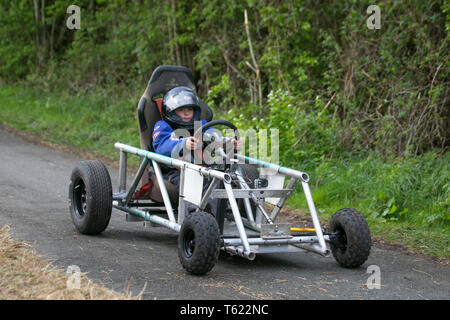 Soapbox derby Wray, Lancashire, Regno Unito. 28 Aprile, 2019. Wacky Wrayces; Callum Hannafin presso il Festival di spaventapasseri competere nel junior soap box derby gare. Il tema del 2019, scelto dalla scuola locale è quello di evidenziare i temi del "Evolution: estinto in via di estinzione," esistenti questo divertente festosa comunità evento annuale di Wray Spaventapasseri Festival in Lancashire è ora nel suo ventiseiesimo anno e richiama migliaia di visitatori del villaggio rurale per la celebrazione di aprile. Credito: MediaWorldImages/AlamyLiveNews. Foto Stock