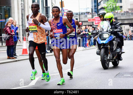 Londra, Regno Unito. Il 28 aprile 2019. Il vincitore della Vergine denaro London Marathon Uomini Elite di gara, Eliud Kipchoge (KEN) (L), Mosinet Geremew (ETH) (C) e Tola Shura Kitata (ETH) (R) passano attraverso il miglio 23. La gara è stata vinta da Eliud Kipchoge (KEN) in un nuovo corso tempo record di 2:02:37. Credito: Stephen Chung / Alamy Live News Foto Stock